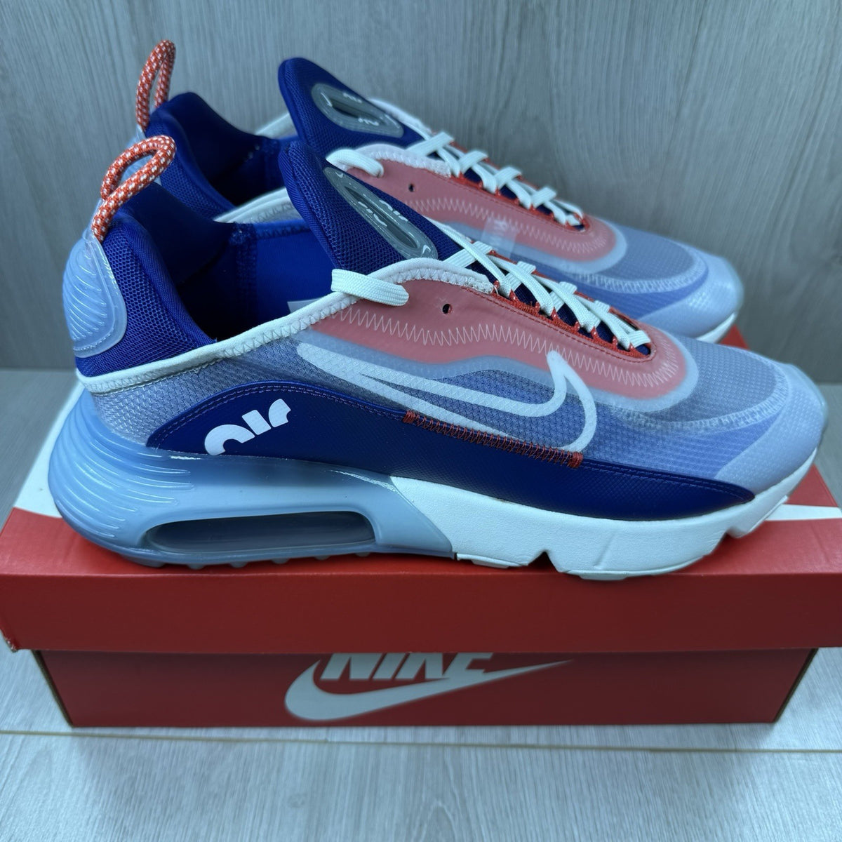Nike Air Max 2090 trainers white with red and blue accents, featuring logo details.