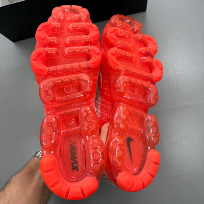 Nike Air VaporMax 2 Flyknit white trainers with hot punch red accents and breathable material.
