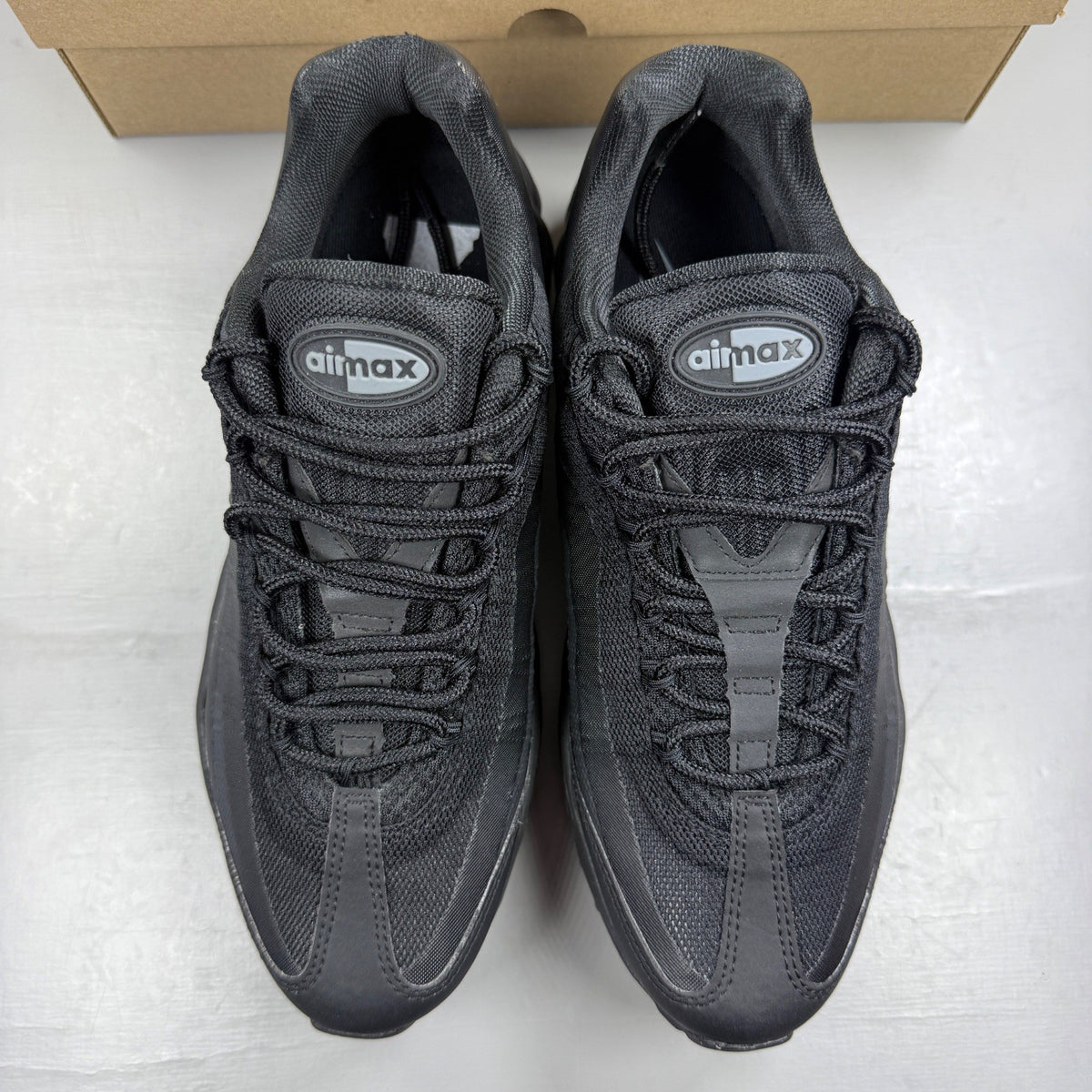Nike Air Max 95 black trainers with cool grey accents and signature logo details.