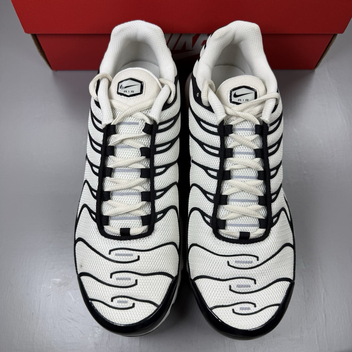 Nike Air Max Plus TN trainers white with black accents and signature logo details.