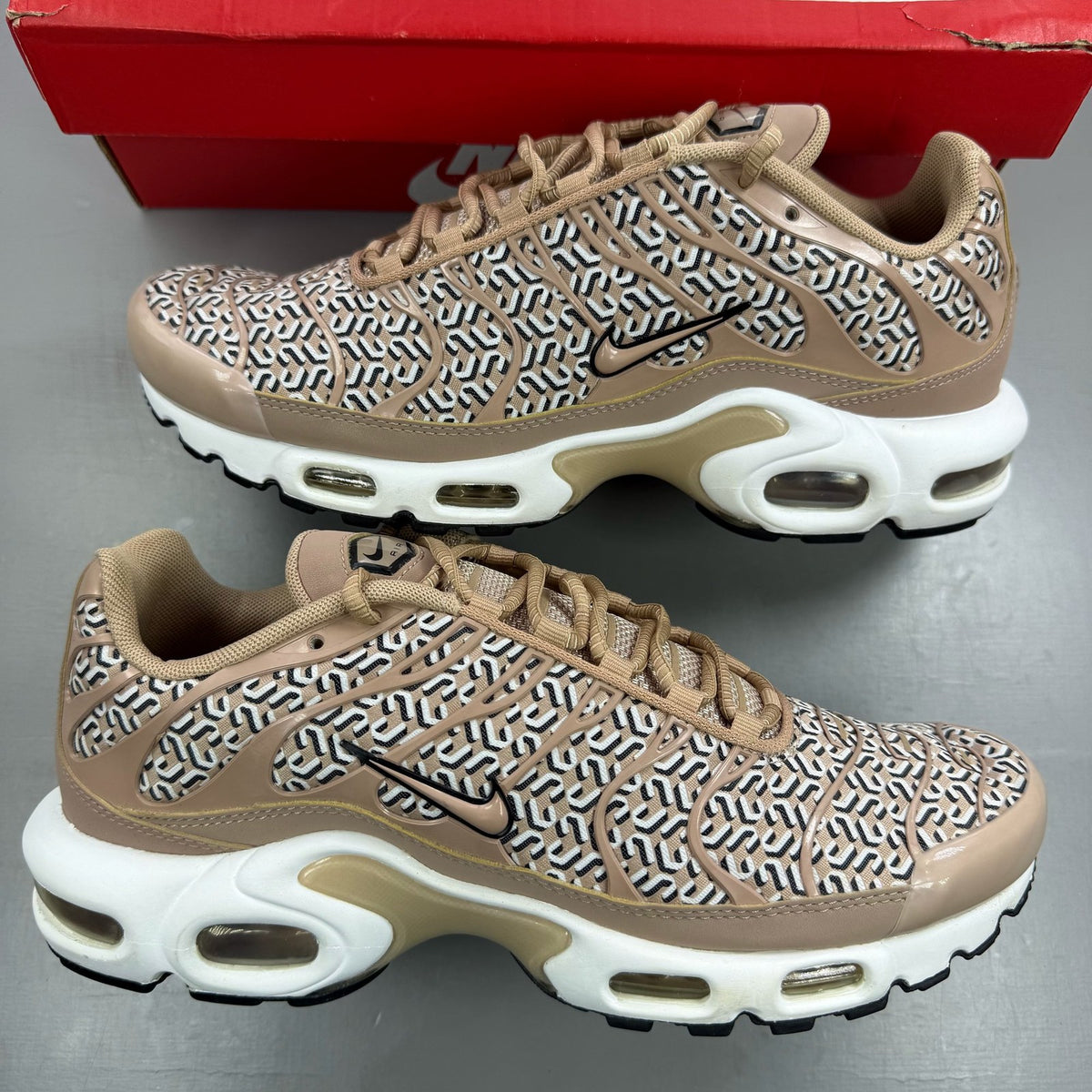 Nike Air Max Plus TN beige trainers with iconic logo and sleek design.