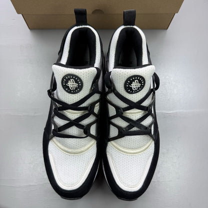 Nike black Air Huarache Light trainers with white accents and mesh detailing.