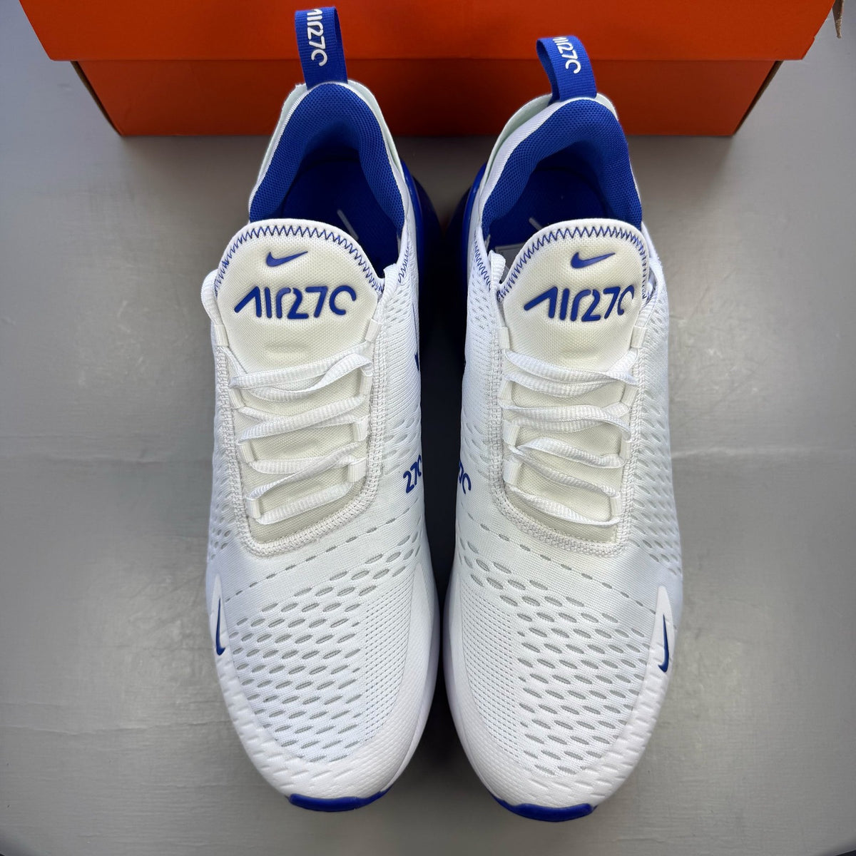 Nike Air Max 270 white trainers with racer blue accents and logo detail.