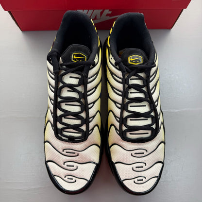 Nike black Air Max Plus TN trainers with bright citron accents and logo detail.