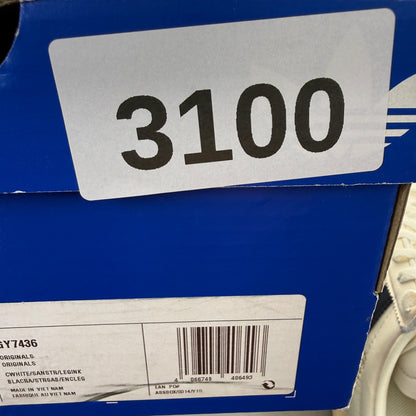Adidas white trainers with navy accents and leather detailing, featuring iconic logo.
