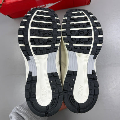 Nike beige athletic shoes with white accents and light bone detailing.