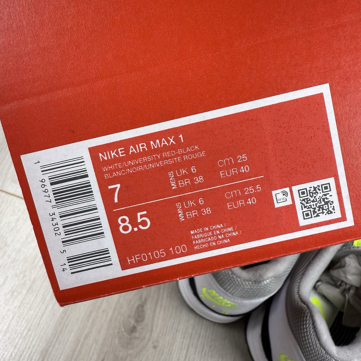 Nike Air Max 1 trainers white with chili volt accents and black detailing.