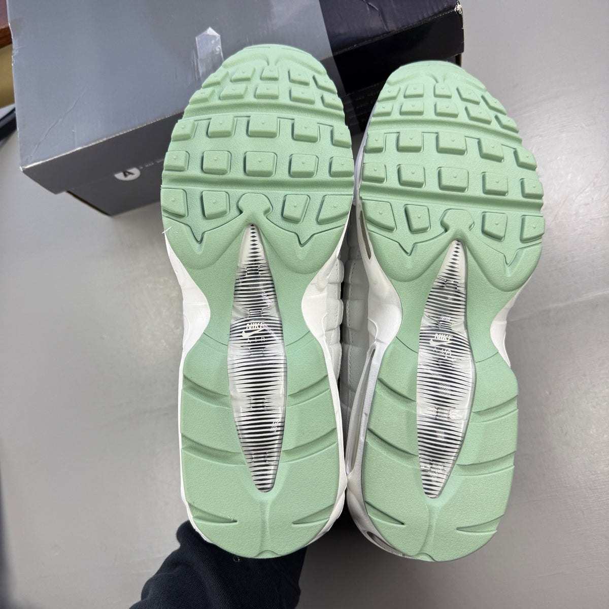 Nike running shoes white with green accents and distinctive Air Max cushioning.
