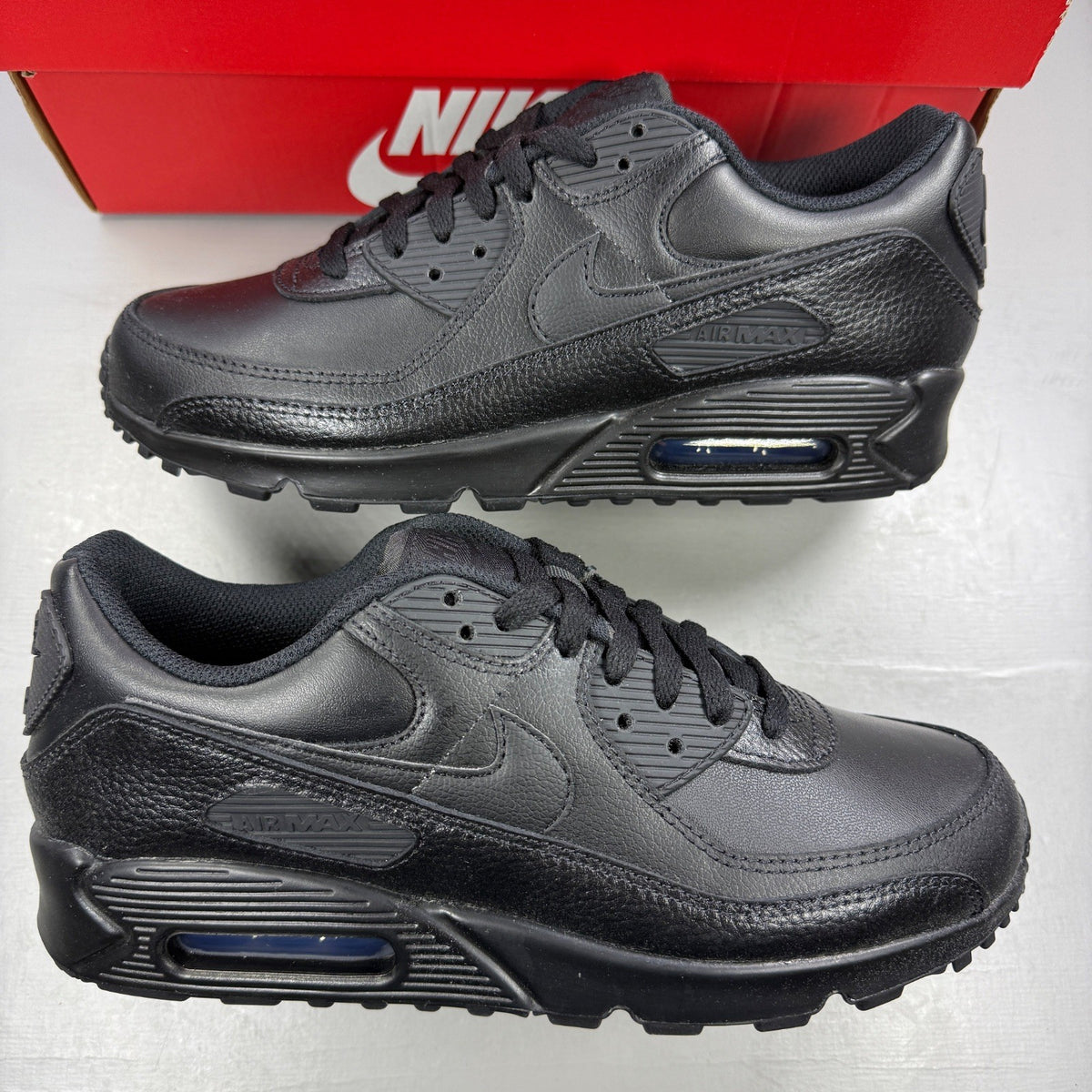 Nike athletic shoes black leather with Air Max branding and textured design.