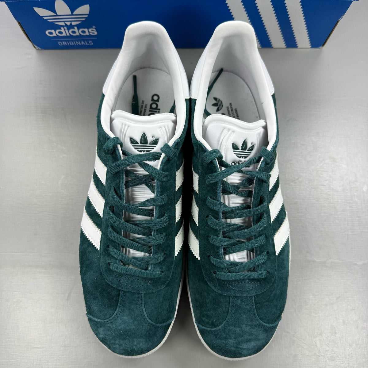 Adidas green suede Gazelle trainers with white stripes and logo detail.