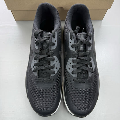 Nike black trainers with dark grey accents and white air bubbles, featuring signature logo.