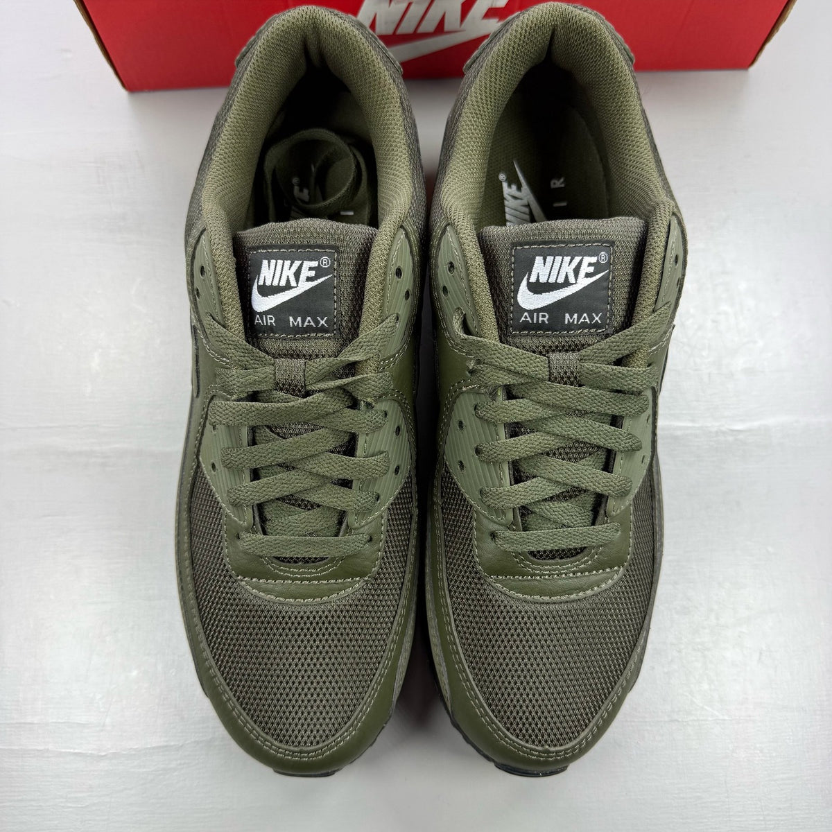 Nike Air Max 90 olive green trainers with reflective detailing and black accents.