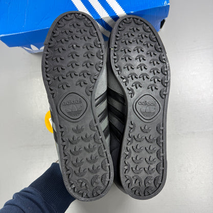 Adidas grey skate shoes with black accents and logo detail on tongue.