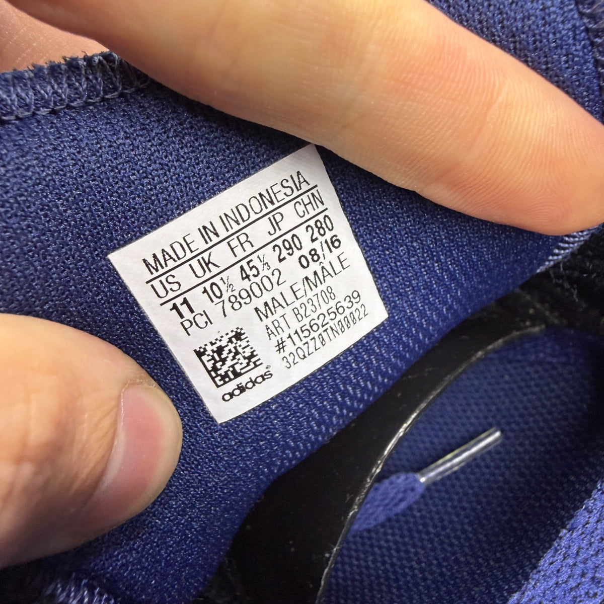 Adidas blue trainers with black accents and signature three-stripe logo.