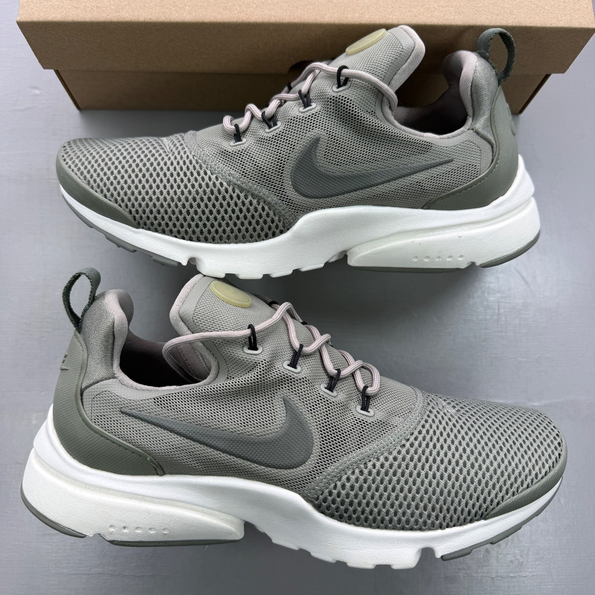 Nike trainers khaki green mesh upper with white sole and logo details.
