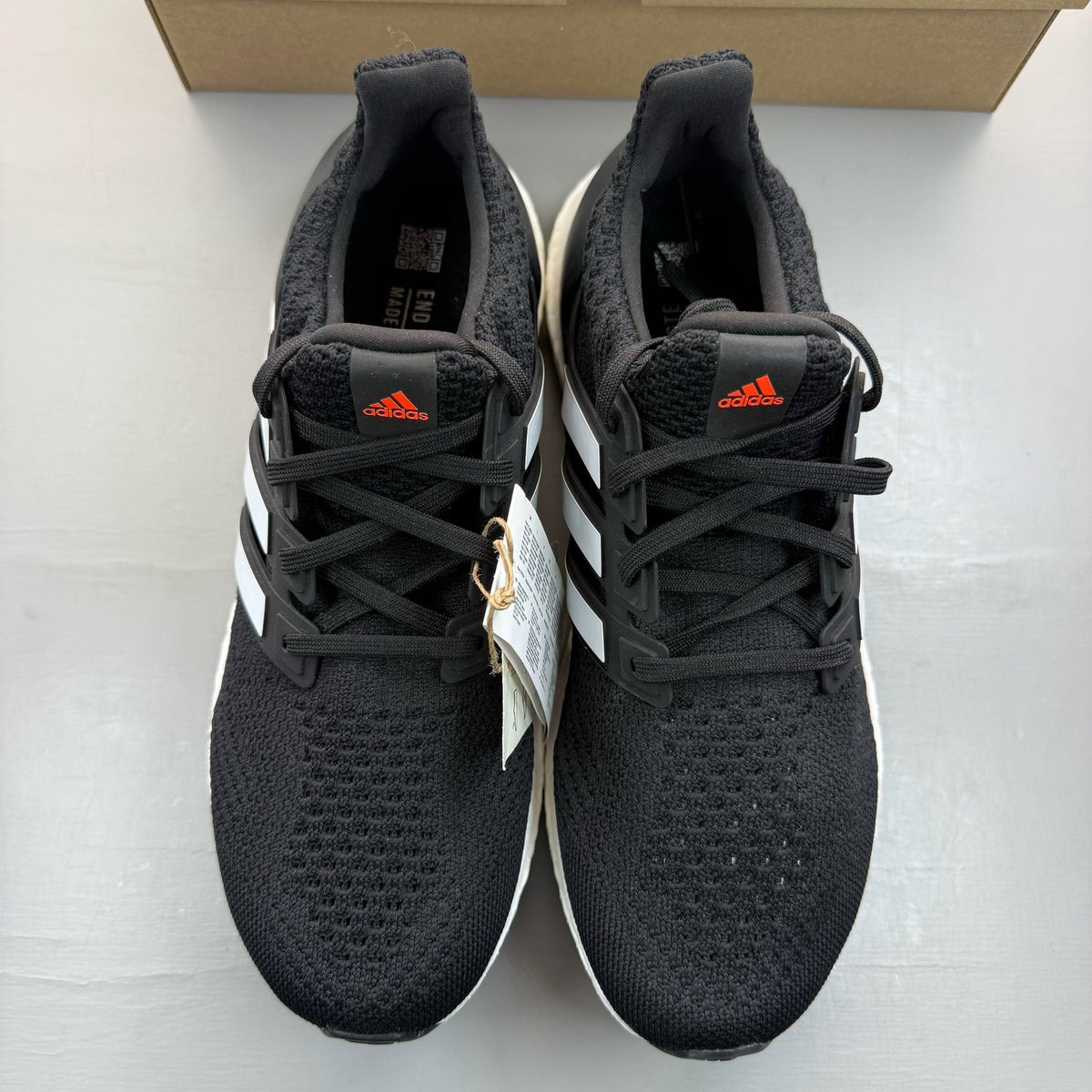 Adidas black Ultra Boost 5.0 trainers with white accents and logo detailing.