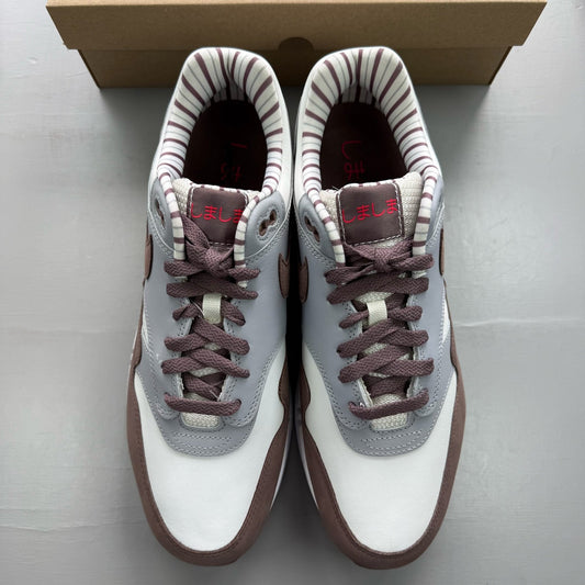 Nike Air Max 1 brown trainers with premium Shima Shima pattern and logo details.