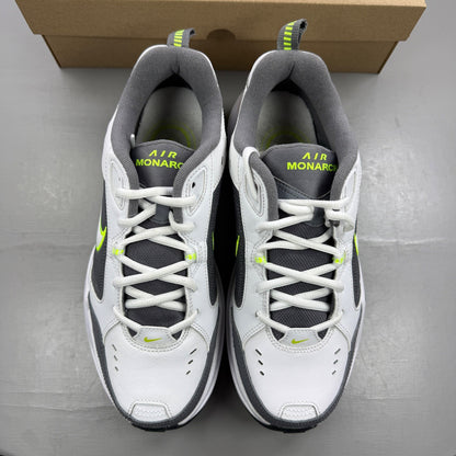 Nike Air Monarch IV white trainers with cool grey and green accents, featuring logo detail.