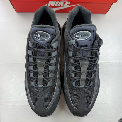 Nike black trainers with grey accents and signature swoosh logo, size UK 9.5.