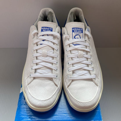 Adidas white trainers with blue and beige accents, featuring classic logo detail.
