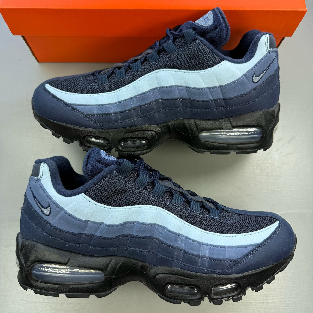Nike Air Max 95 blue trainers with big bubble sole and logo detailing.