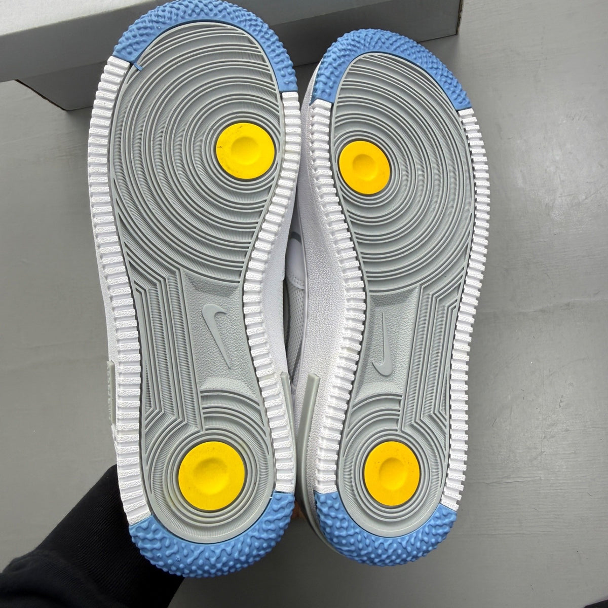 Nike Air Force 1 React white trainers with smoke grey accents and logo details.