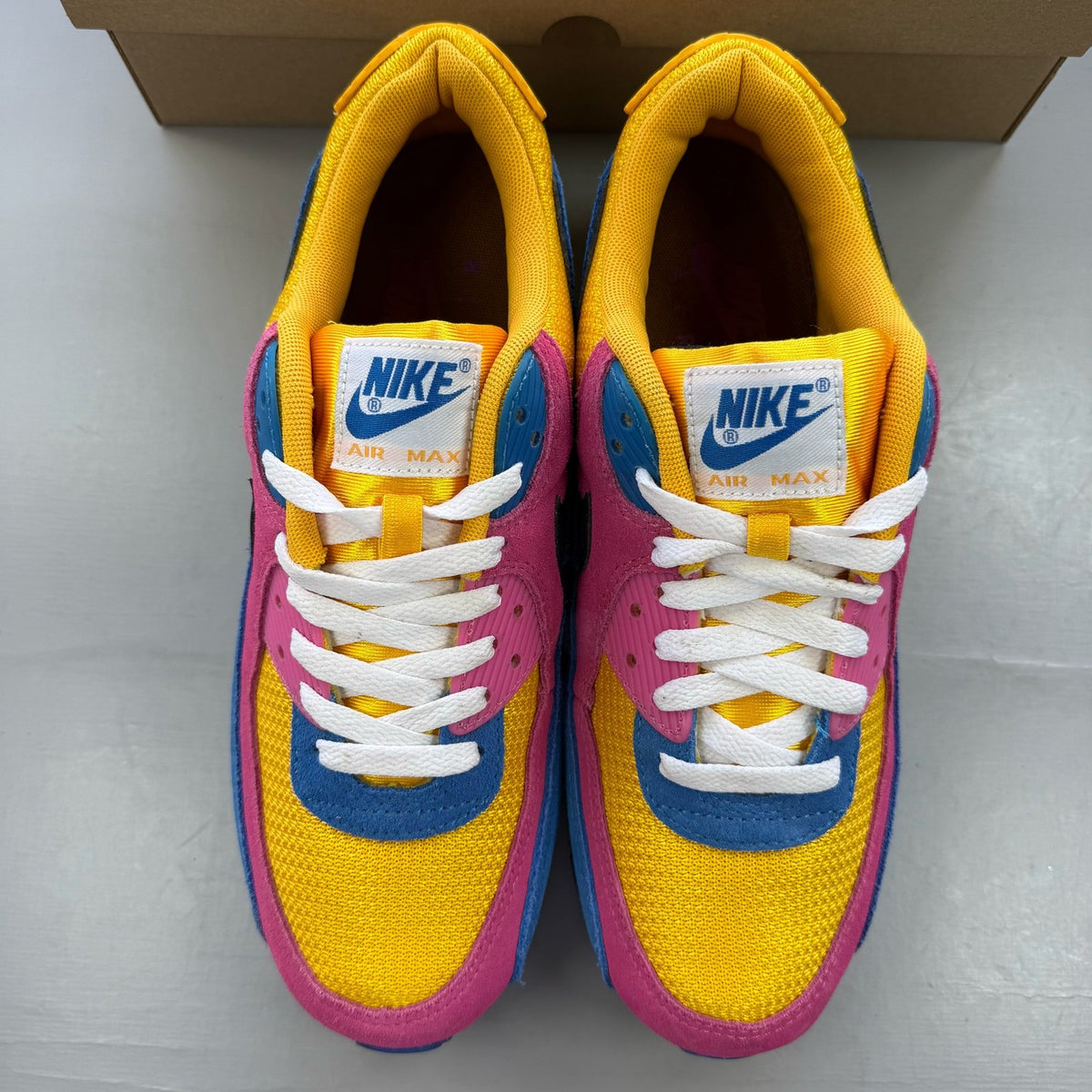 Nike Air Max 90 multicolor suede trainers with yellow and blue accents.