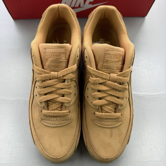 Nike Air Max 90 Premium beige trainers with gum sole and subtle branding details.