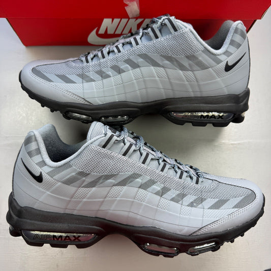Nike Air Max 95 grey trainers with caution strip detailing and black accents.