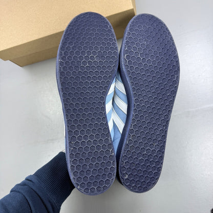 Adidas athletic shoes sky blue with white stripes and logo detail.