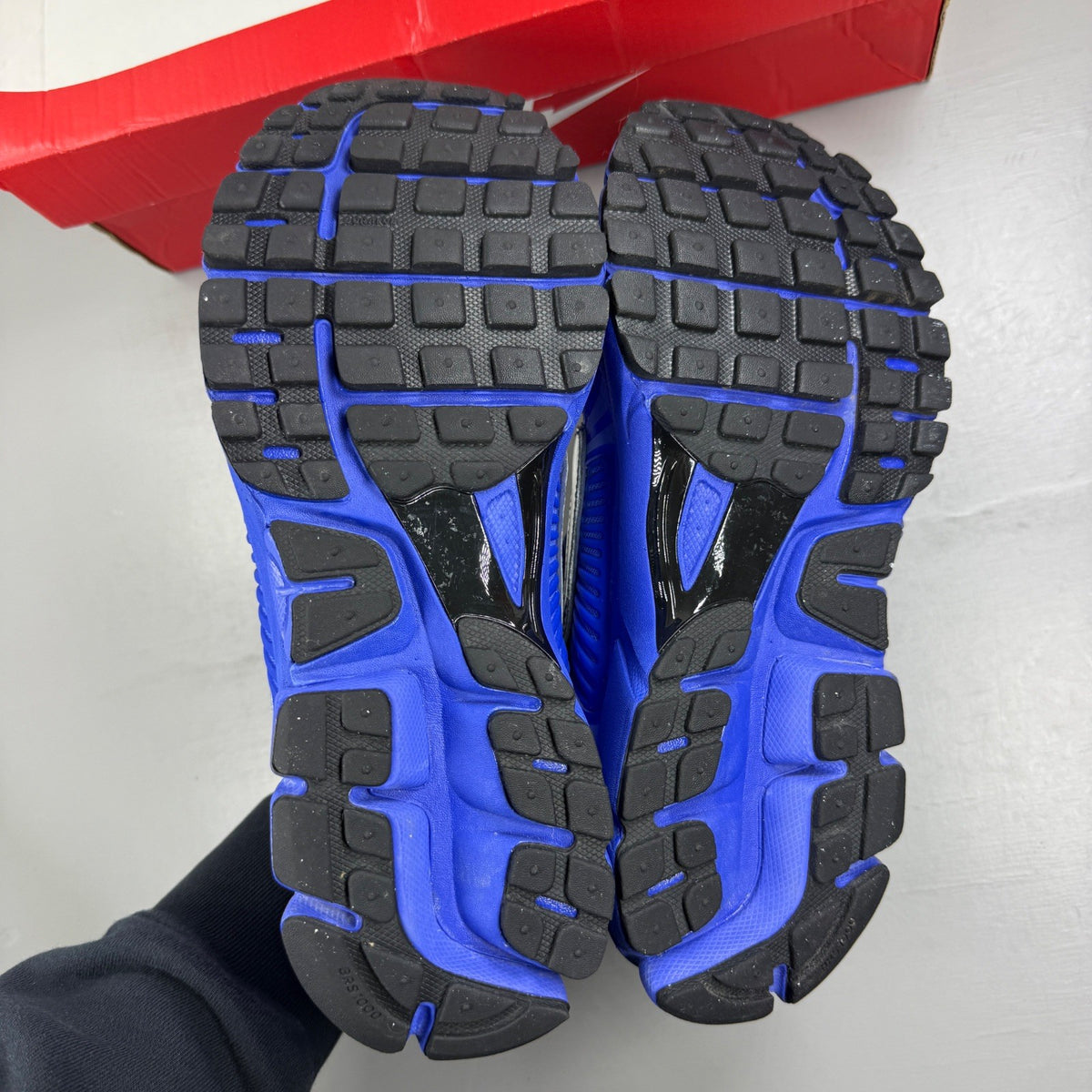 Nike Zoom Vomero 5 blue trainers with silver accents and logo detailing.