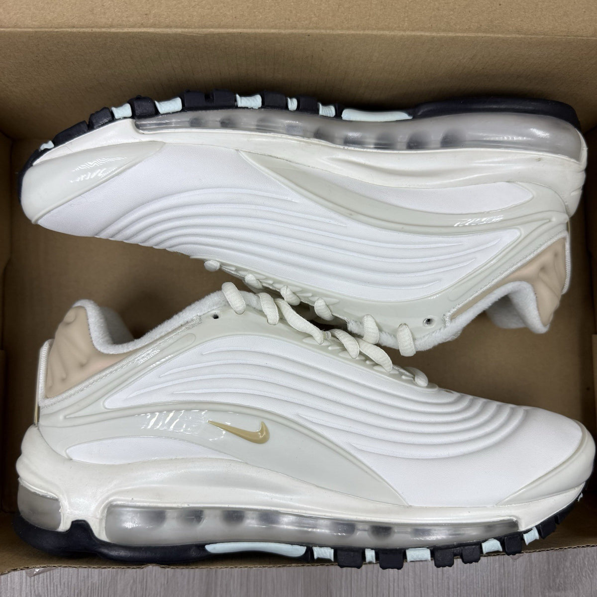 Nike Air Max Deluxe SE beige trainers with unique pattern and logo details.