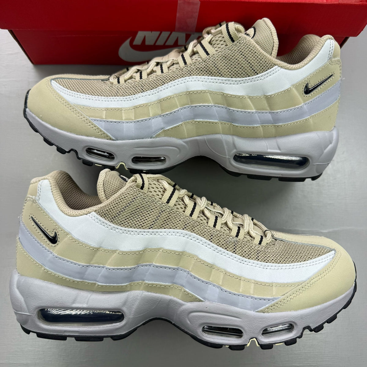 Nike Air Max 95 beige trainers with desert khaki accents and logo detailing.