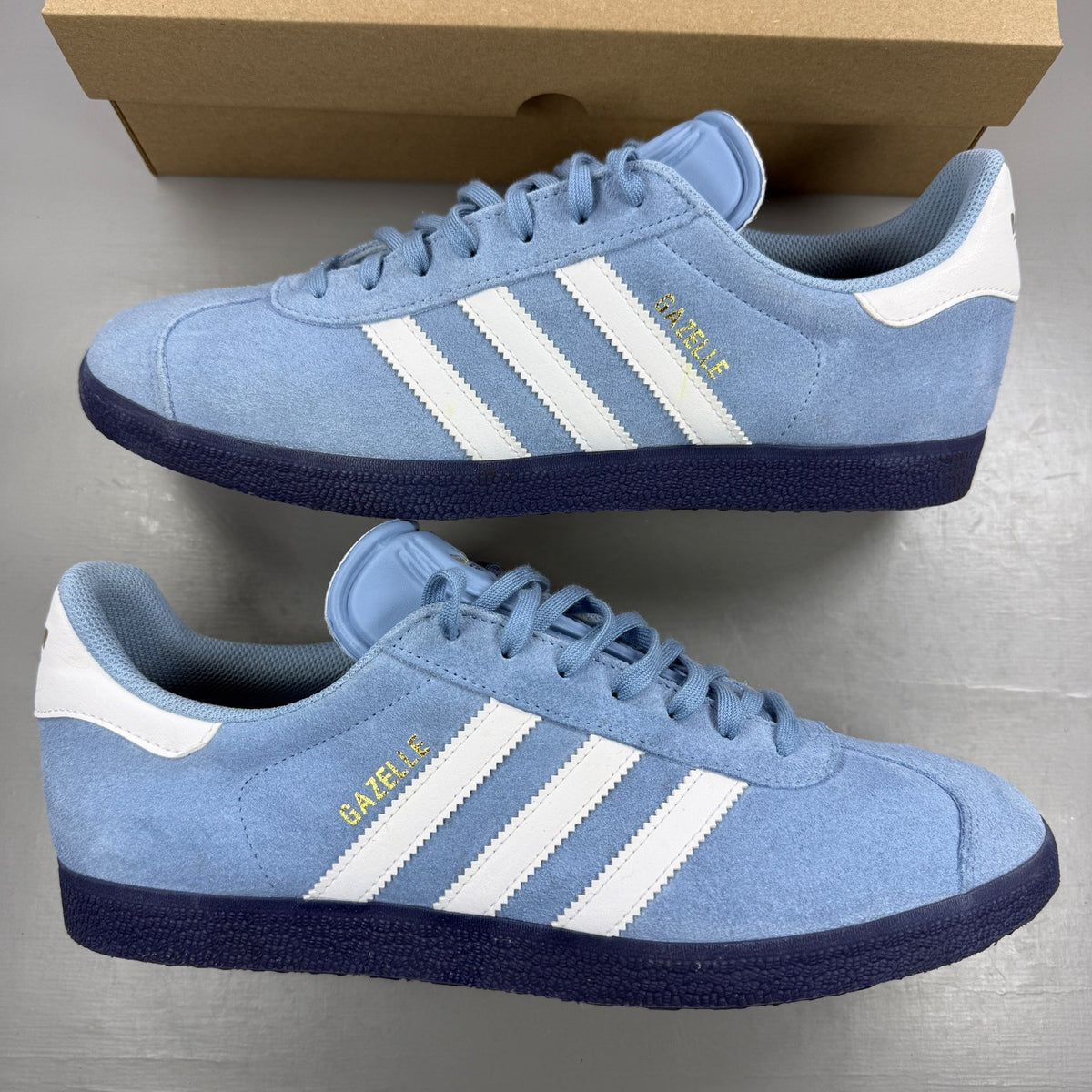Adidas athletic shoes sky blue with white stripes and logo detail.