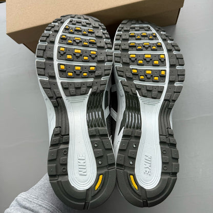 Nike grey P-6000 trainers with laser orange accents and mesh material.