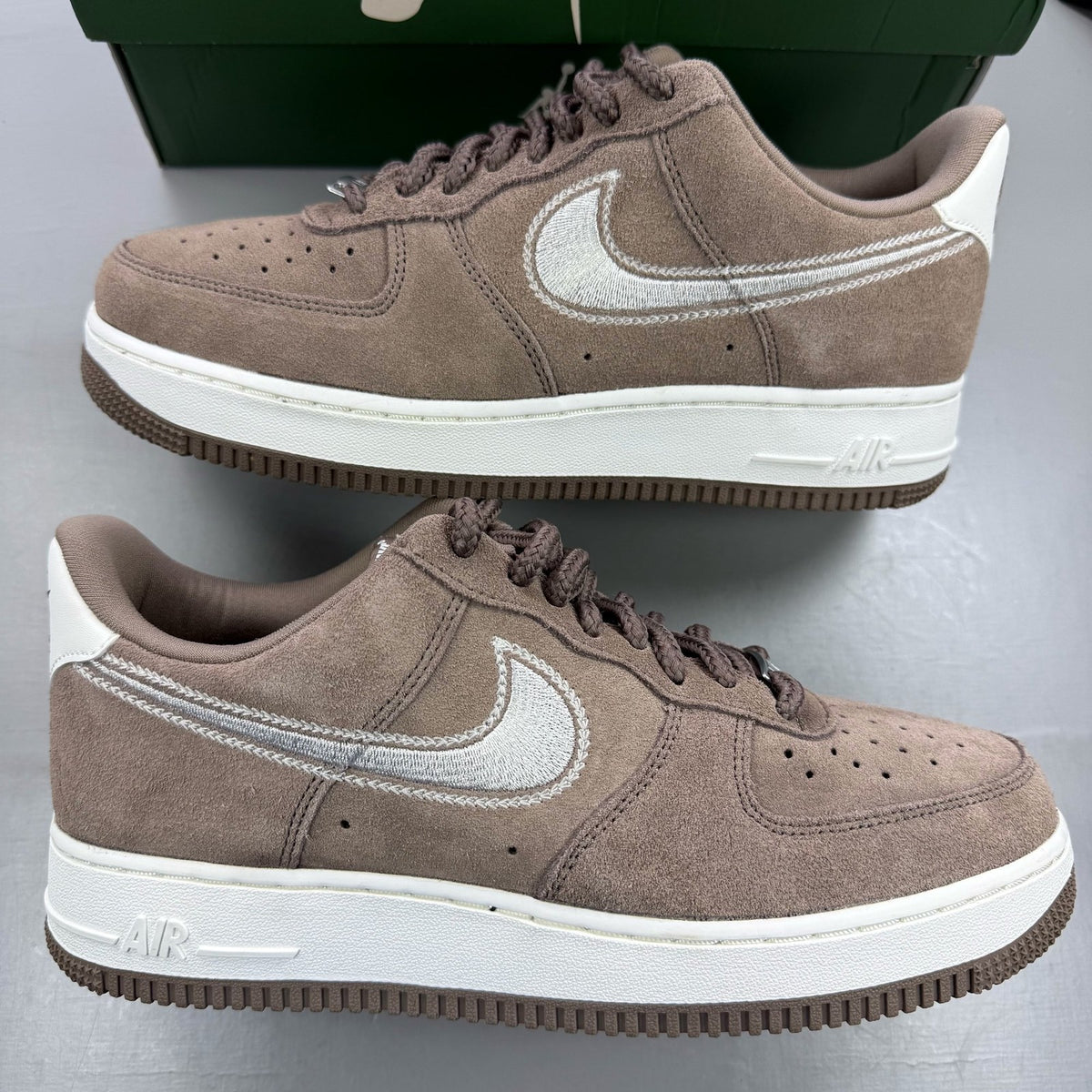 Nike brown trainers with leather upper and signature swoosh logo.