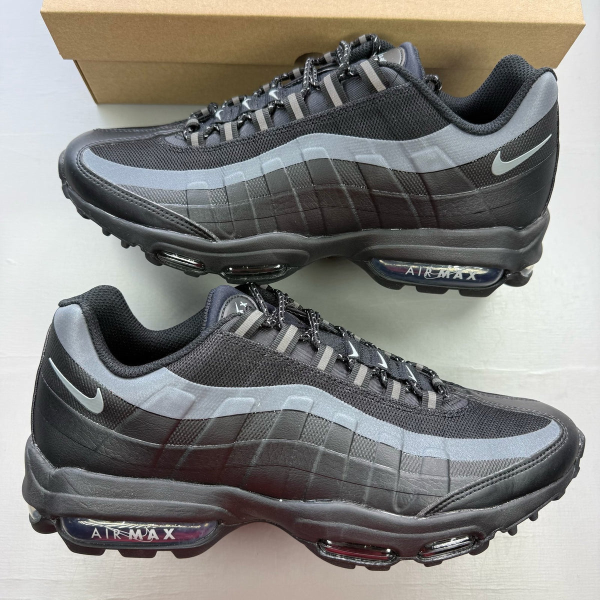 Nike black Air Max 95 trainers with reflective details and logo.
