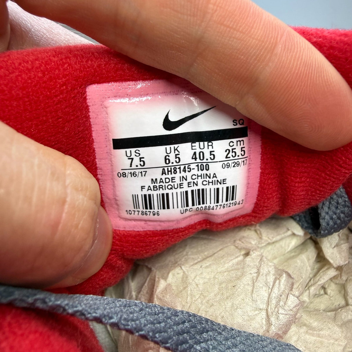 Nike Air Max 1 trainers grey red white with logo and mesh material details.