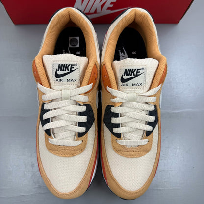 Nike Air Max 90 orange trainers with copper accents and signature swoosh logo.