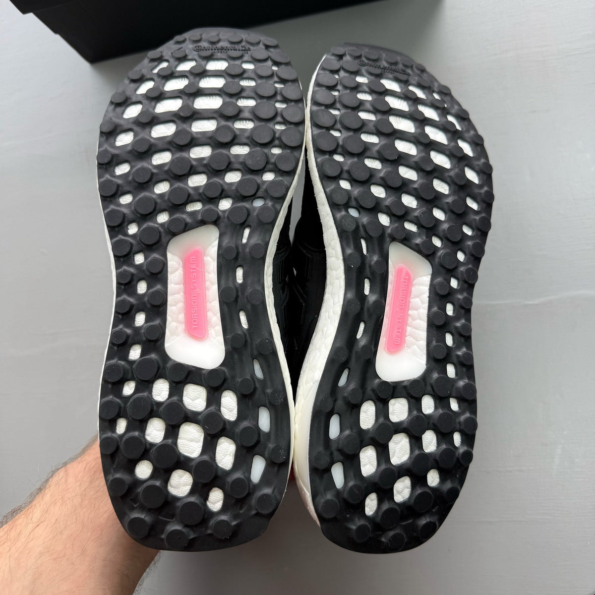 Adidas Ultraboost 1.0 black trainers with white accents and signature three-stripe logo.