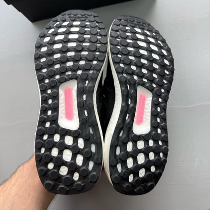 Adidas Ultraboost 1.0 black trainers with white accents and signature three-stripe logo.