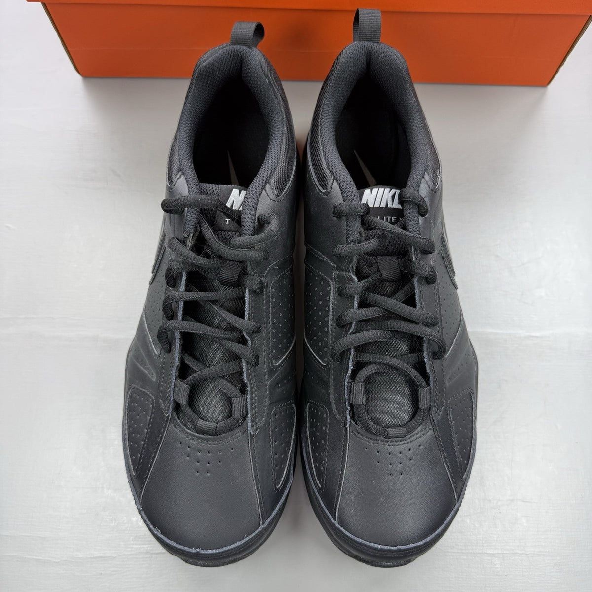 Nike black trainers with metallic silver accents and grey detailing, featuring logo on tongue.
