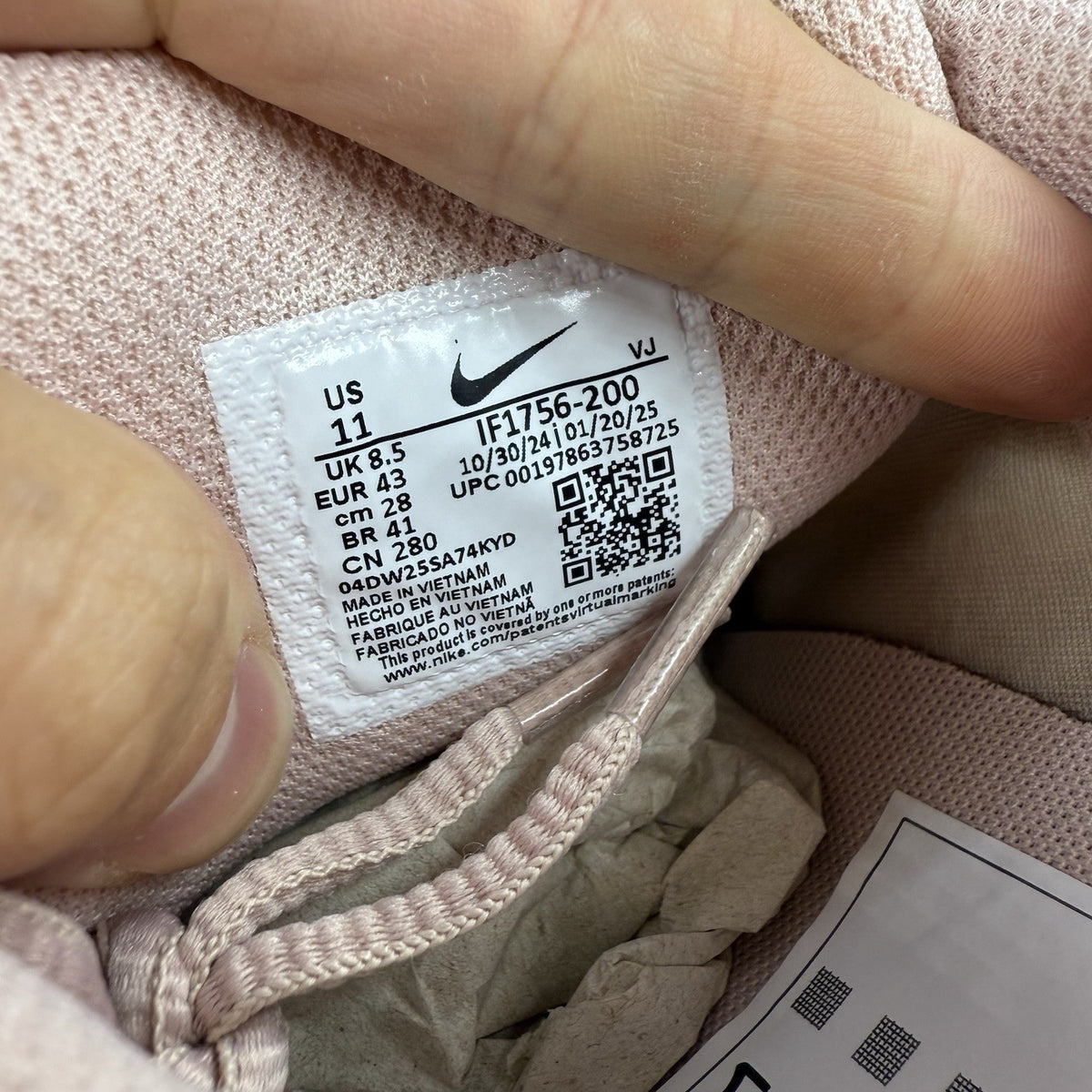 Nike beige trainers with pink accents and mesh detailing, featuring iconic swoosh logo.