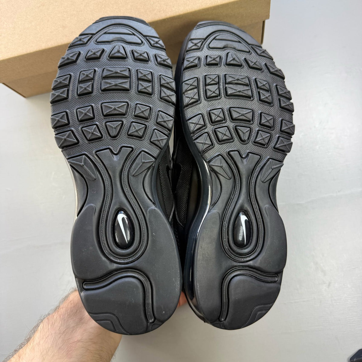 Nike Air Max 97 black low top trainers with sleek design and signature logo.