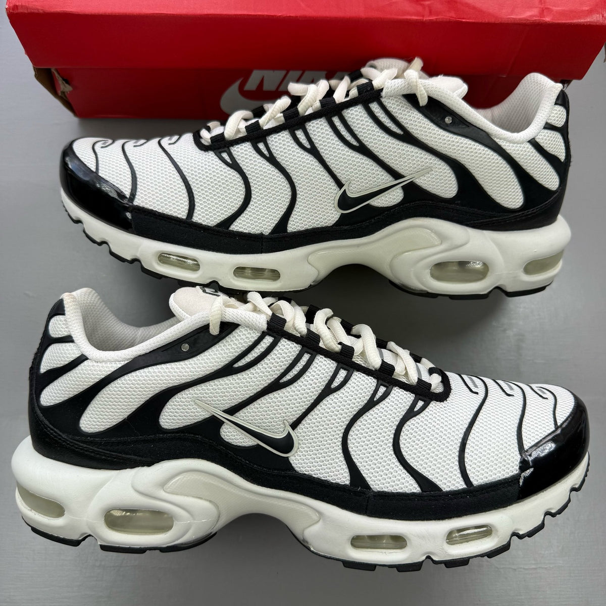 Nike Air Max Plus TN trainers white with black accents and signature logo.