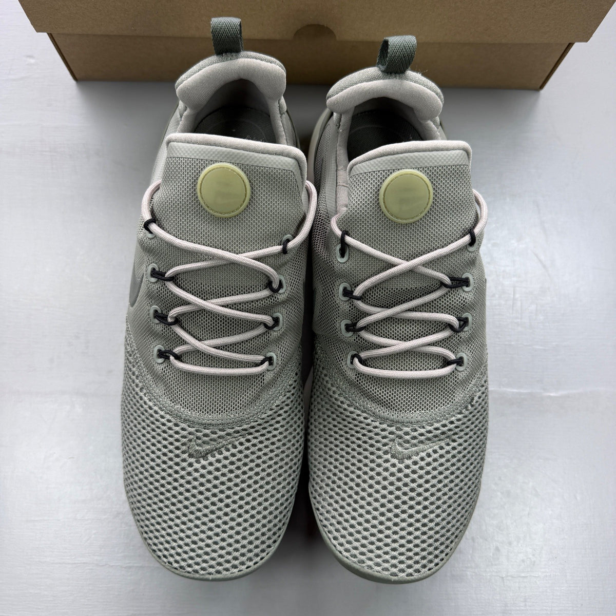 Nike trainers khaki green mesh upper with white sole and logo details.