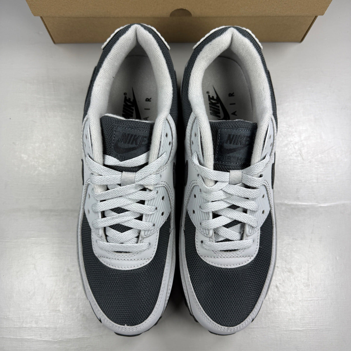 Nike trainers light smoke grey with black accents and iconic swoosh logo.