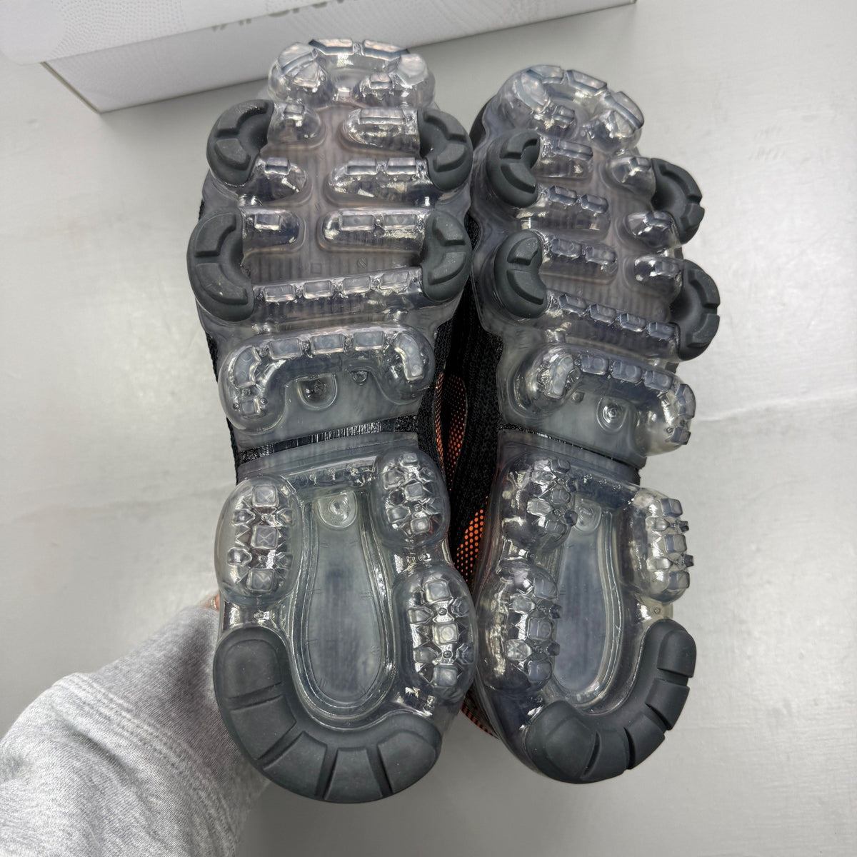 Nike Air VaporMax Flyknit 3 black trainers with total orange accents and breathable knit material.