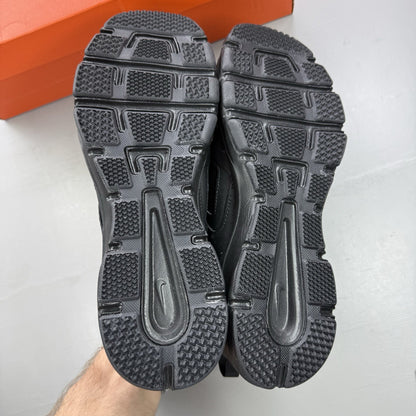 Nike black trainers with metallic silver accents and grey detailing, featuring logo on tongue.