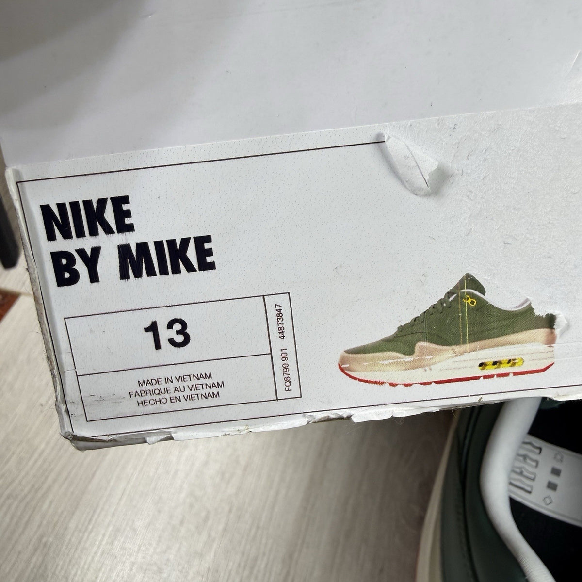 Nike Air Max 1 trainers green with white and silver accents, featuring iconic logo.